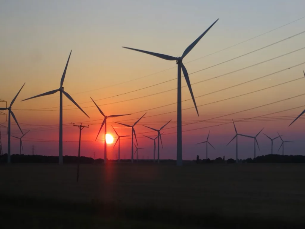 Parc éolien et ligne électrique au coucher du soleil